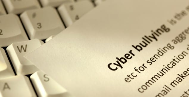 Angled shot of piece of paper with the definition of "cyberbullying" typed on it