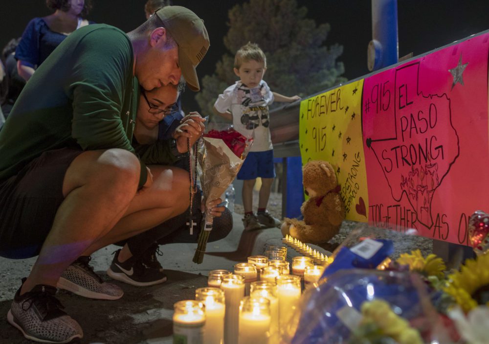 People praying at a memorial for victims of a mass shooting in El Paso, Texas
