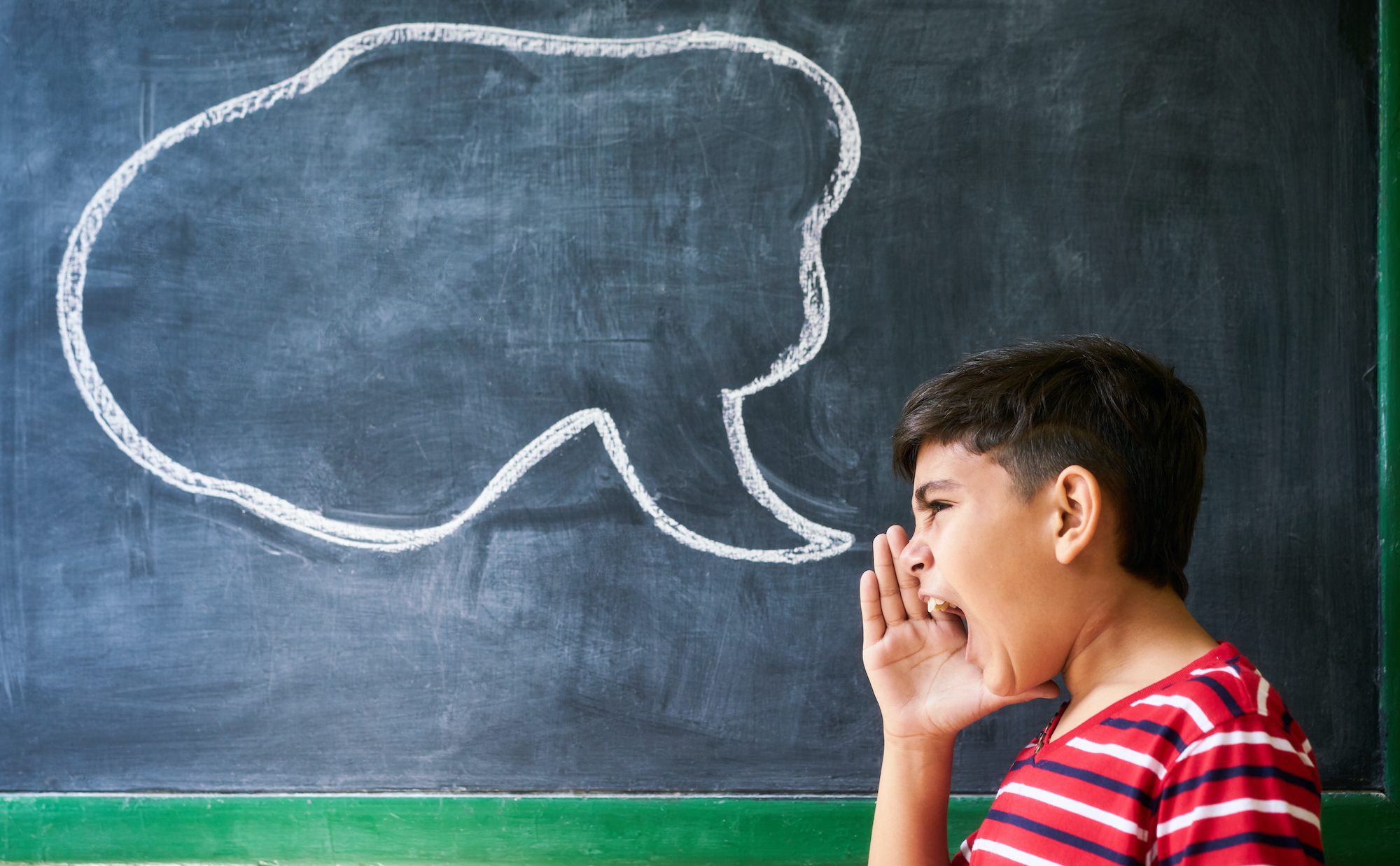 Kid yelling in front of a chalkboard