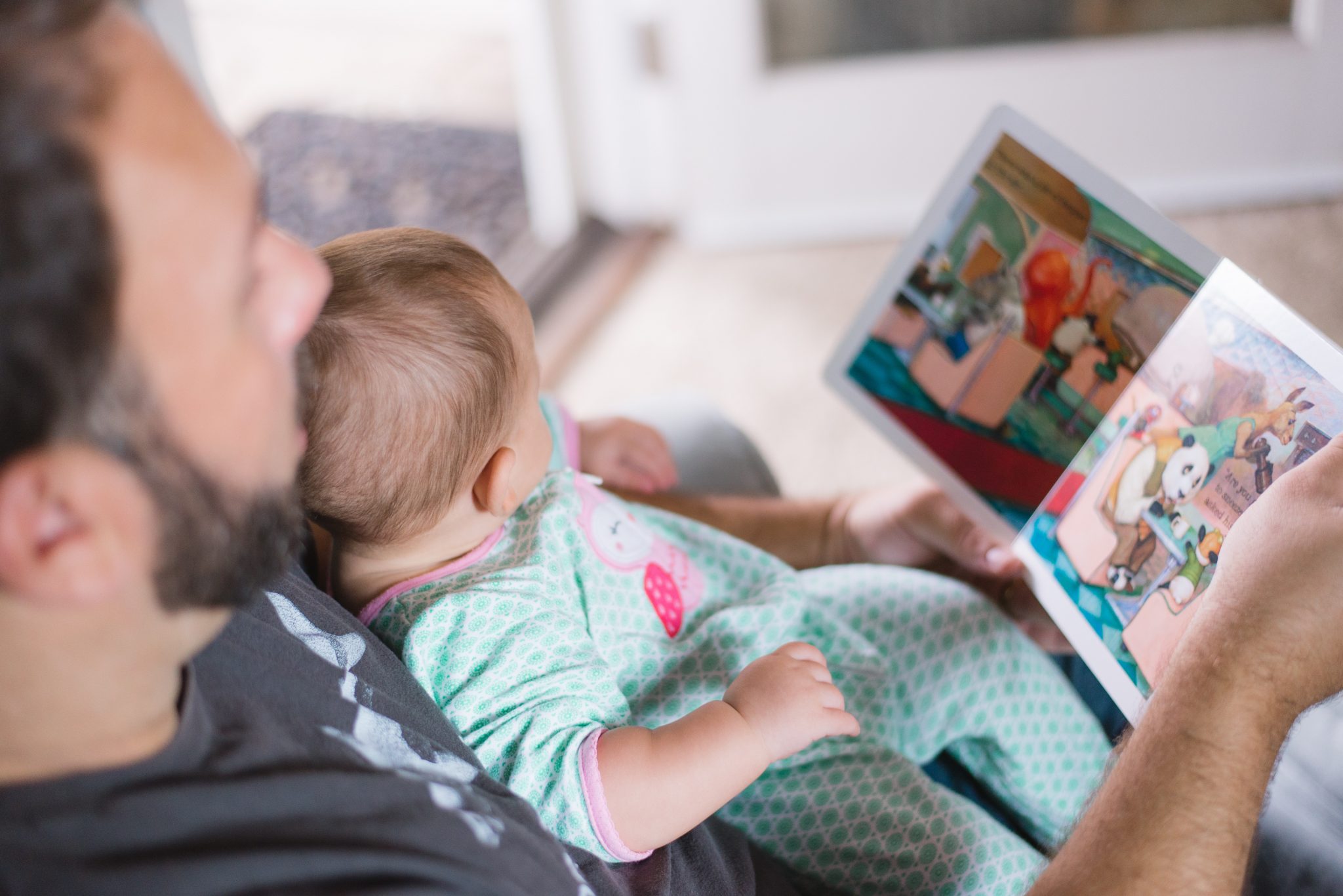Importance of Sleep - father reading bedtime story to baby