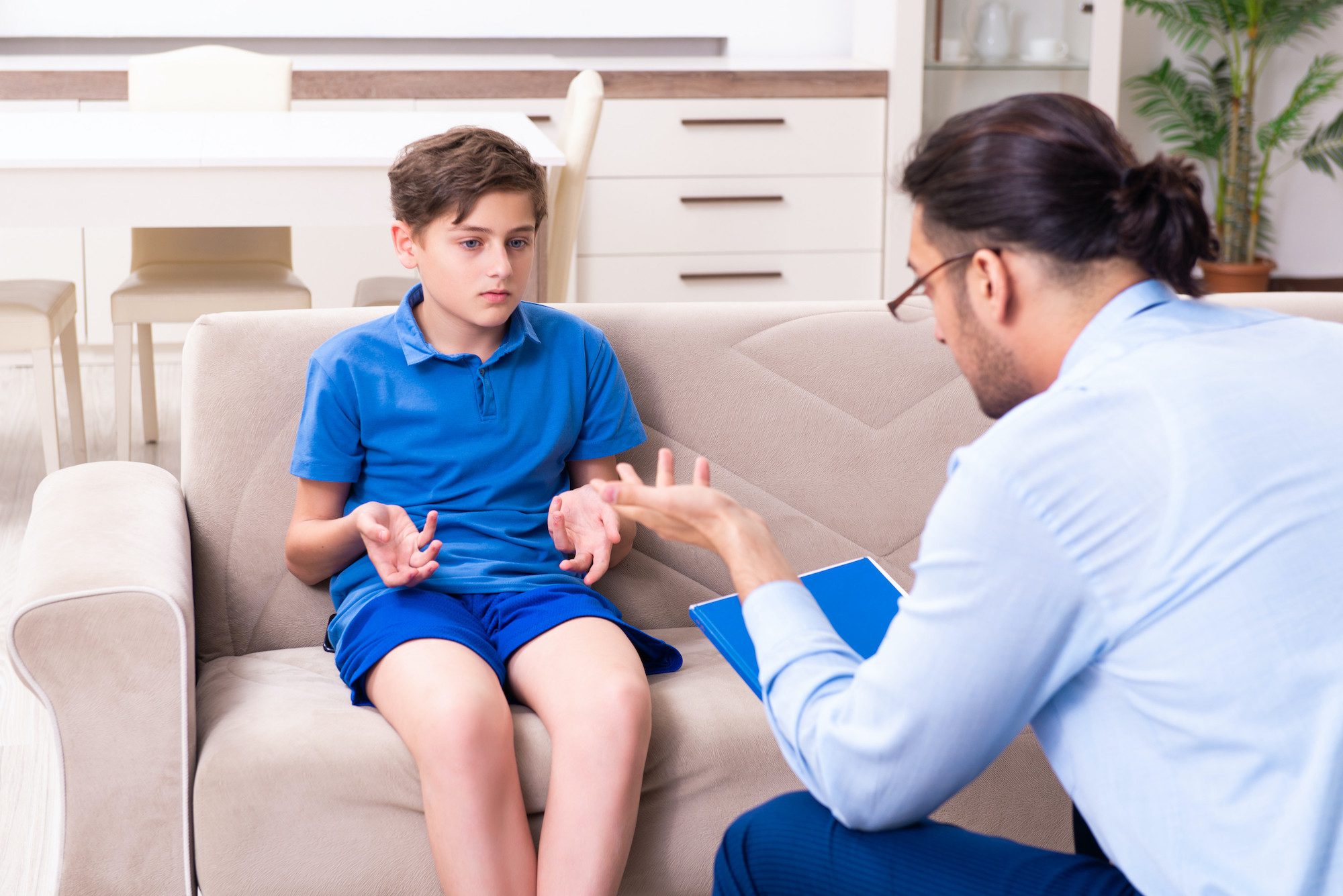 CBT for ADHD - Psychologist talking to boy on a couch