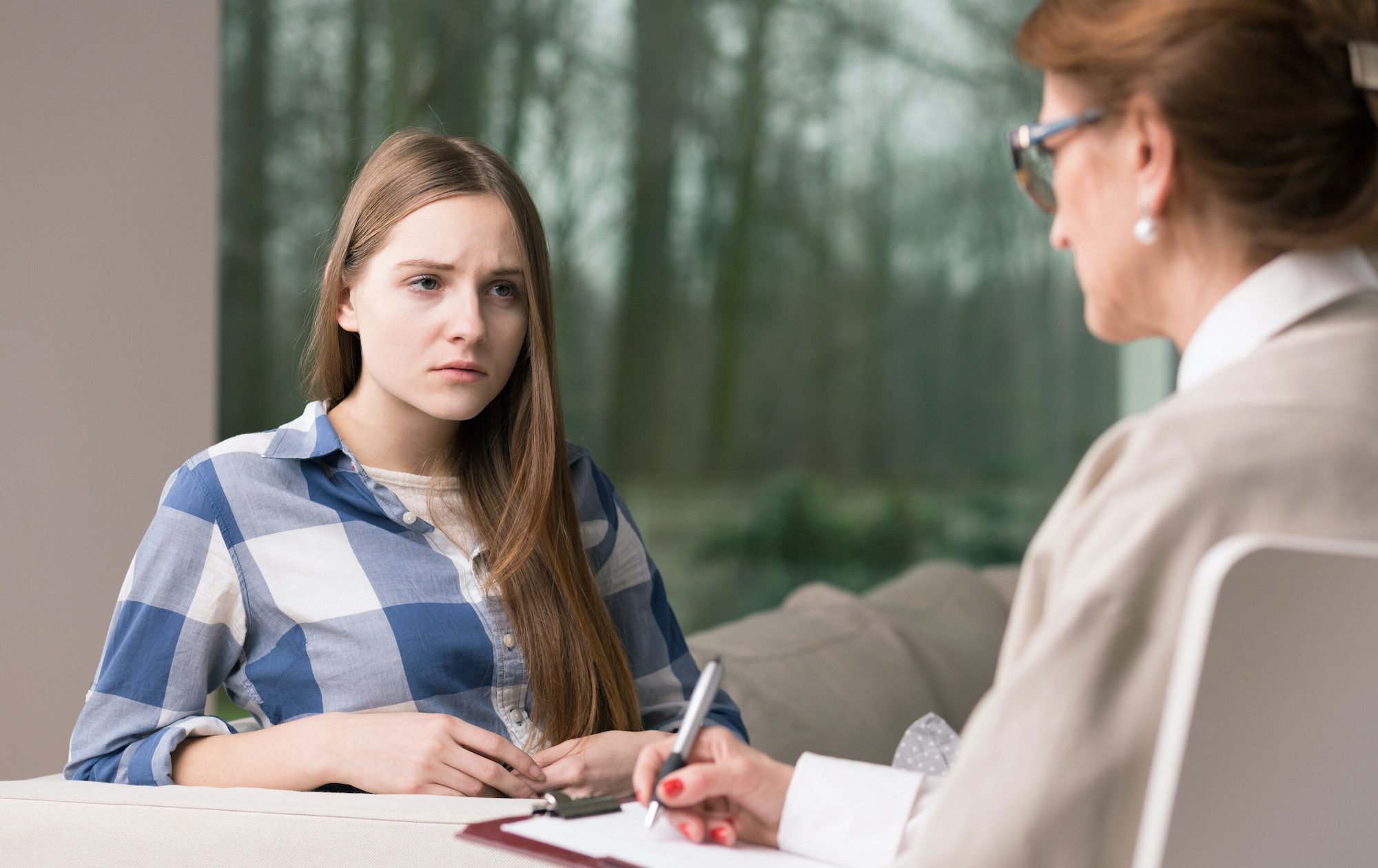 Stressed teenage girl talking to psychologist