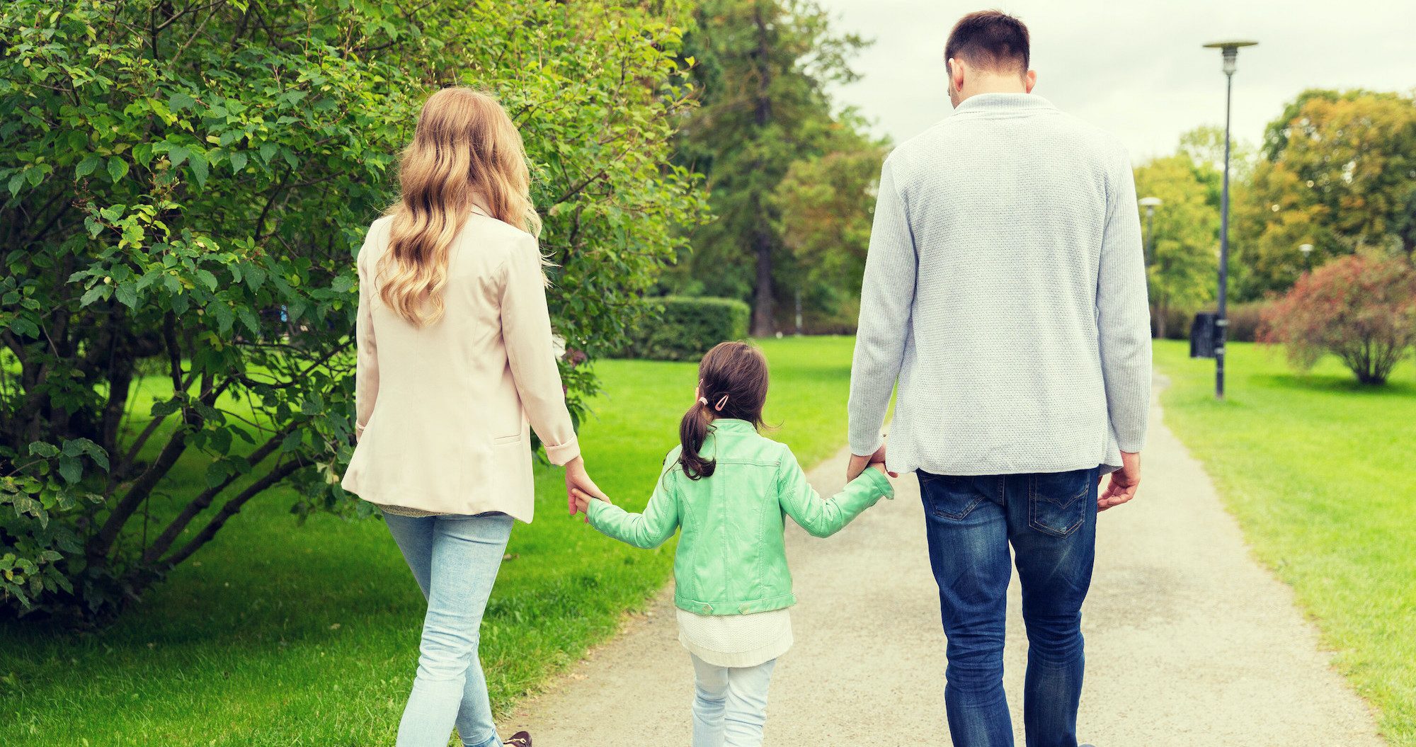 Parents walking with daughter along a road