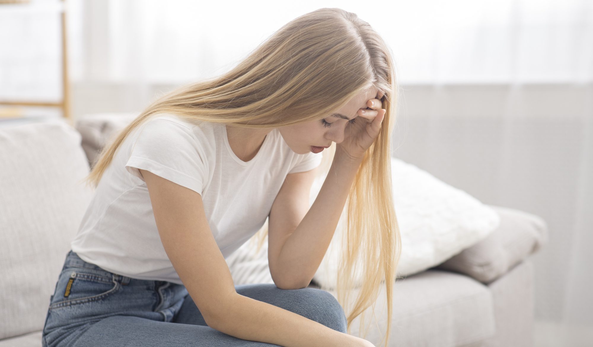 Sad teenager sitting on a couch