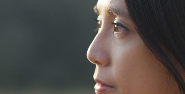 预防自杀: Close up profile of a Chinese woman thinking seriously