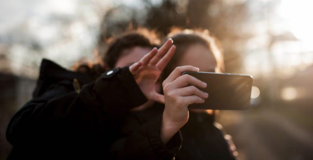 Social Media Body Image - Two teen girls take selfies and stream videos outdoors