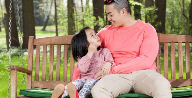 Building Mental Wellness Kids - Father and daughter have a conversation while sitting on a swing