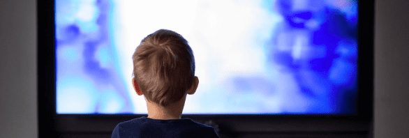 Behind shot of child watching blue tv screen