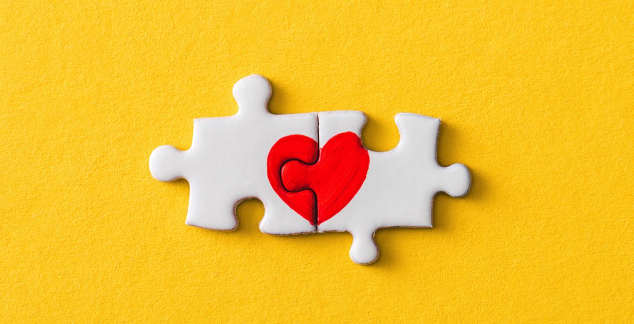 at-risk emotions, connected heart jigsaw puzzle pieces over yellow background