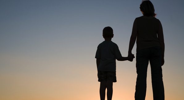 Silhouettes of mother and son at sunset