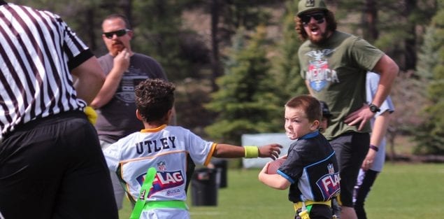 Parents shouting from sidelines at flag football game for 5 and 6 year old athletes