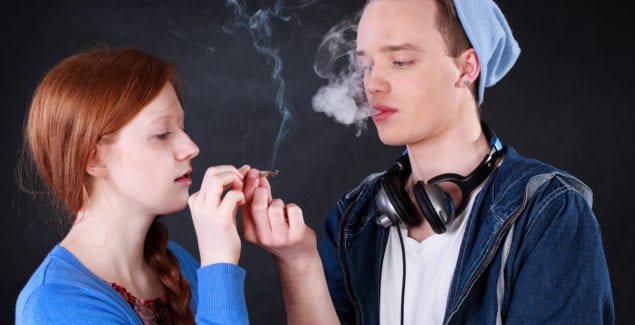Horizontal view of a teenagers smoking marijuana joint