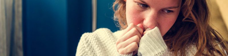 Self-cutting Young girl sitting with long sleeves looking sad