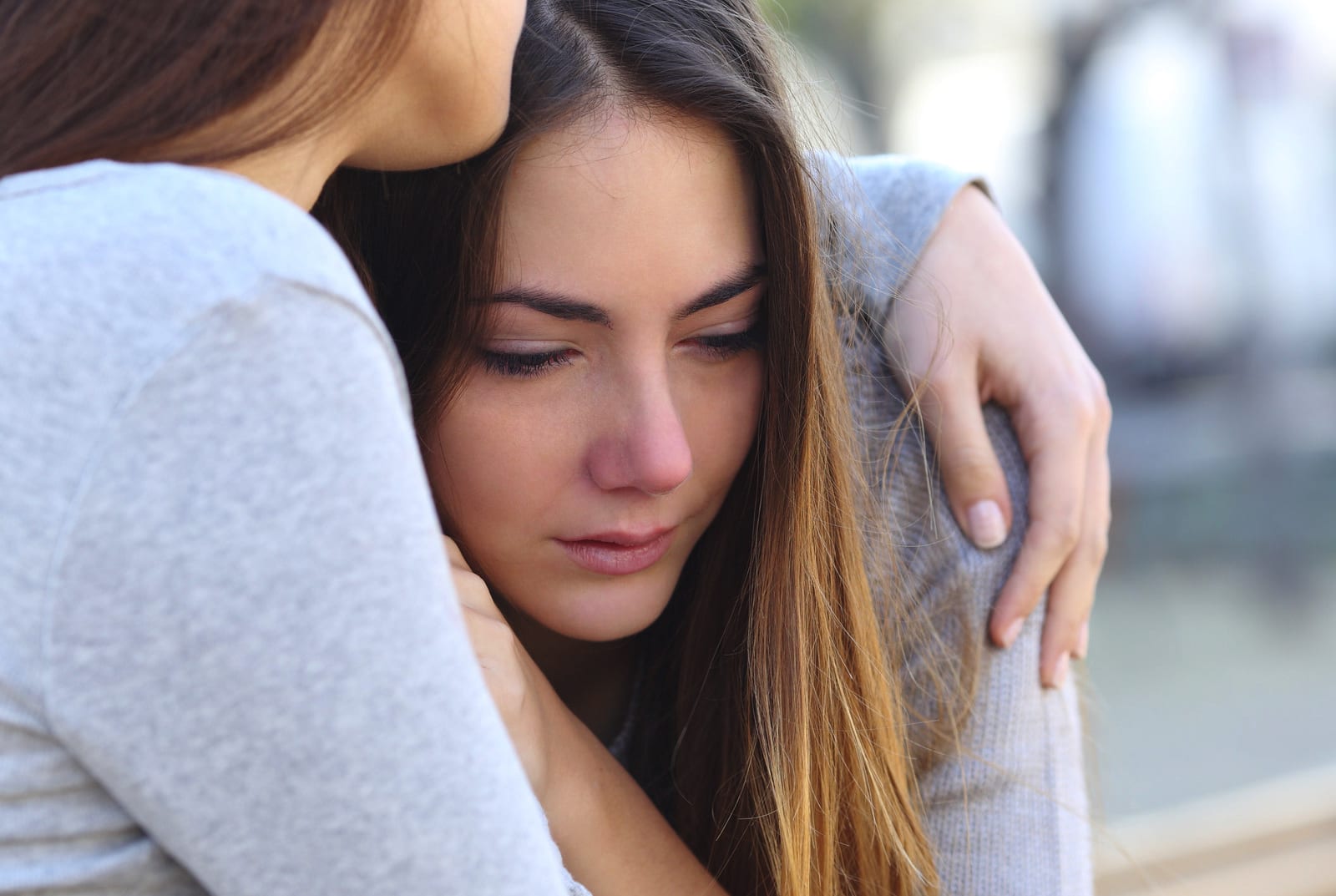 crying teen being held by friend after disclosing sexual assault