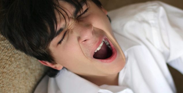 About Sleep - Teen yawning while leaning back on sofa