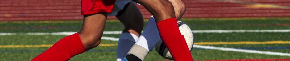 Sports Injury - Close up foot movement on soccer field, two players legs intertwined