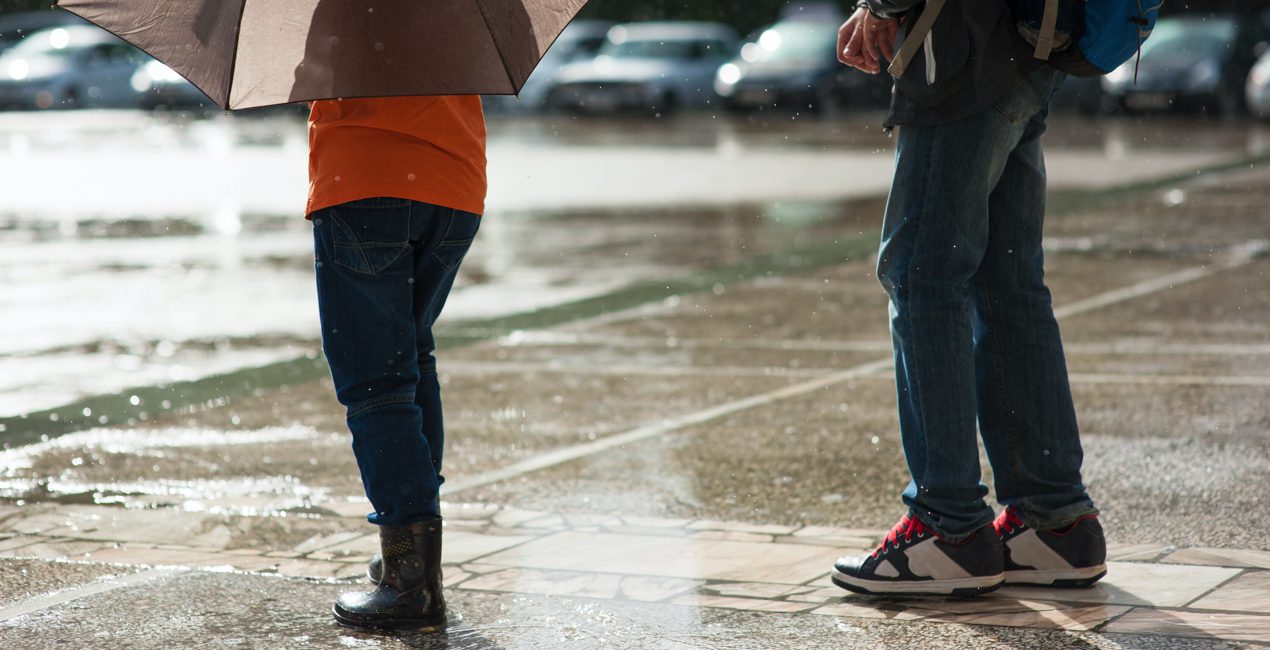 Storm Anxiety - Photo of two people standing in pouring rain on city street