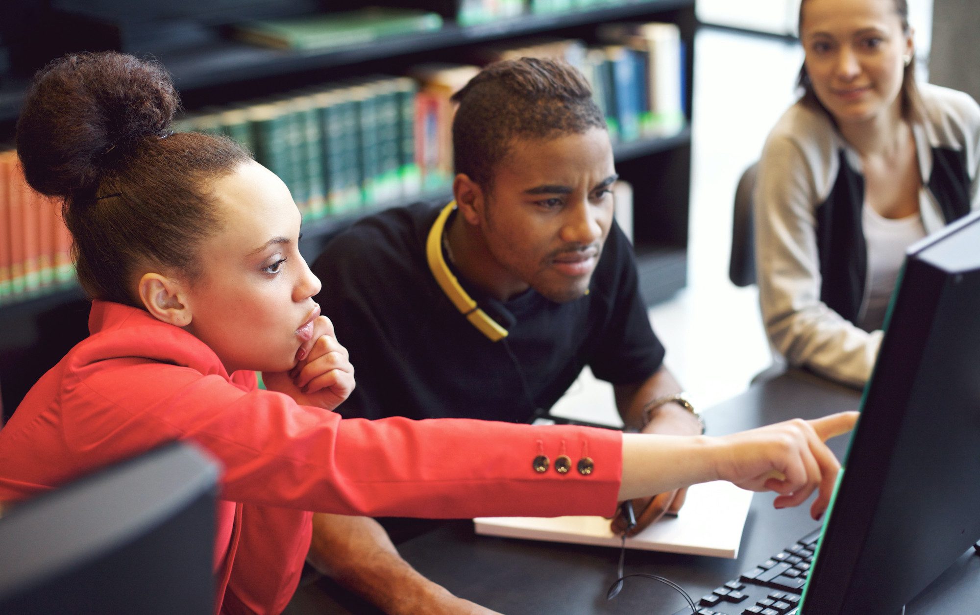 Students doing work in front a library computer