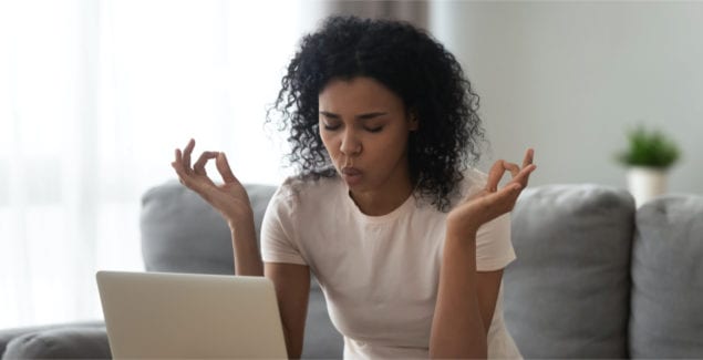 Teacher self-care - African woman sit on couch near laptop take break reduce stress do yoga meditation exercise to calm down