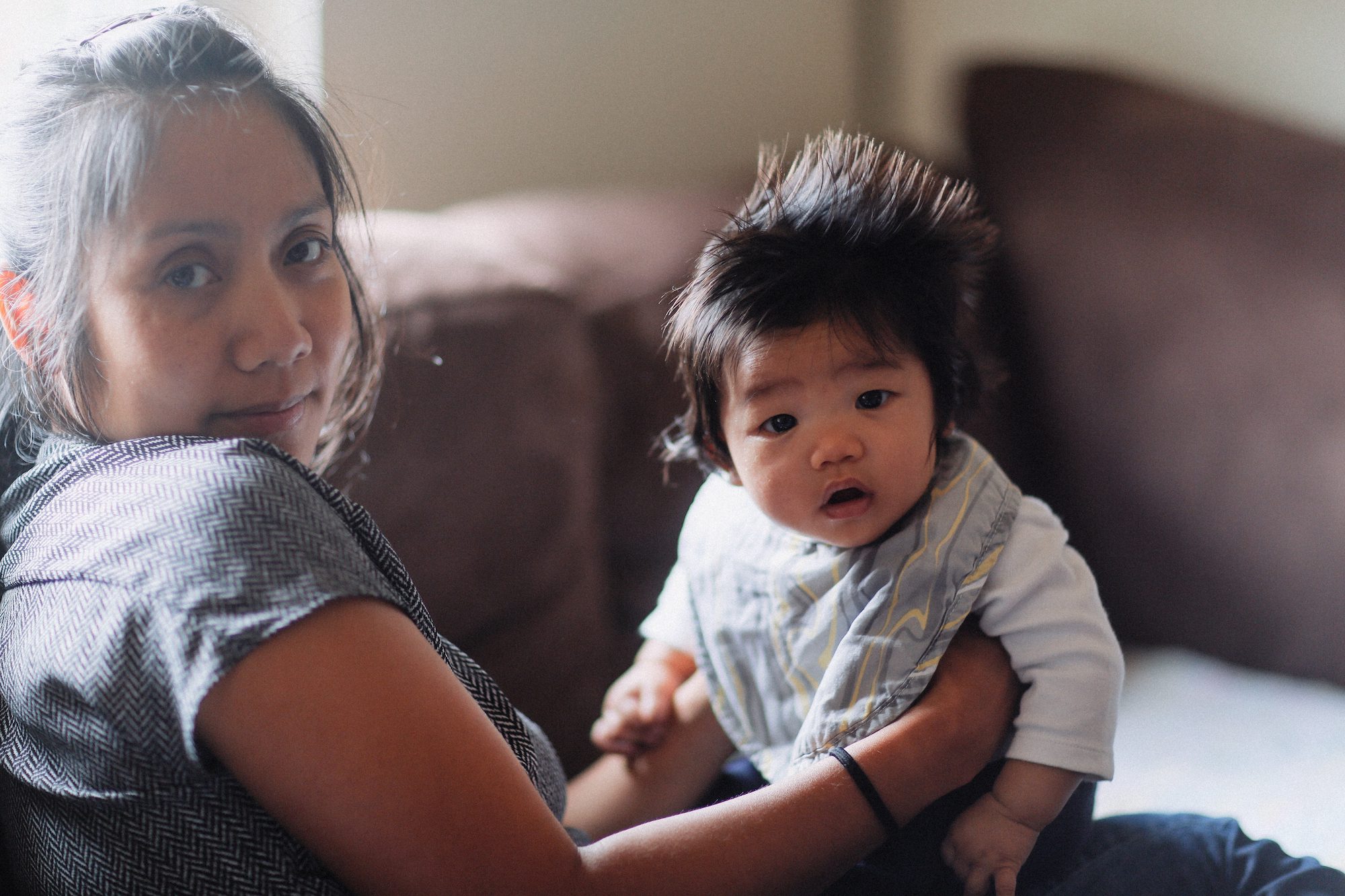 Mom holding baby while sitting on a couch