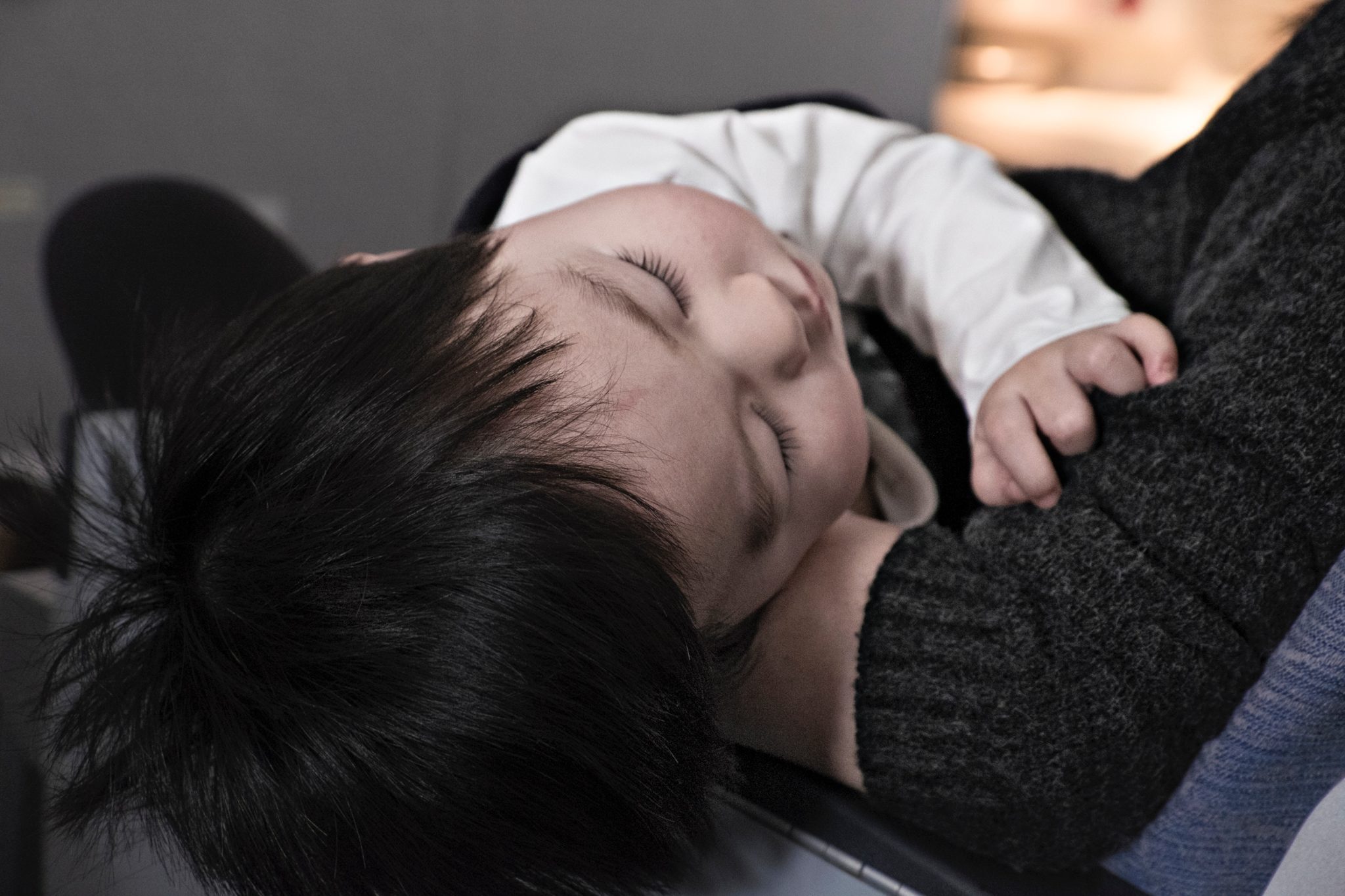 Young toddler asleep on parent's lap