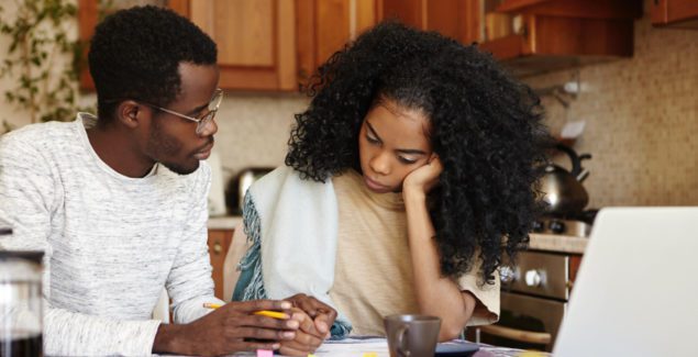Trauma - Young african american couple sitting at table having serious conversation