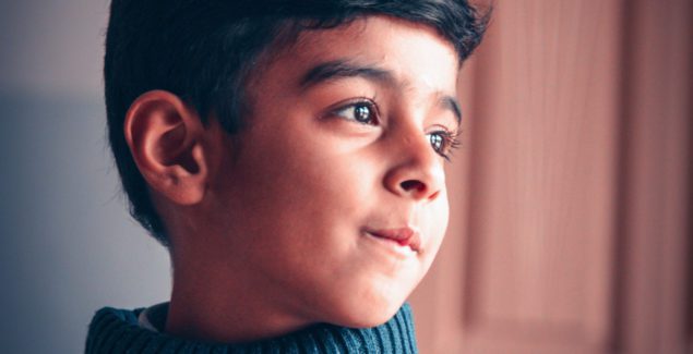 Bullied Because of Religion - close up of school-age Pakistani boy's face looking thoughtful