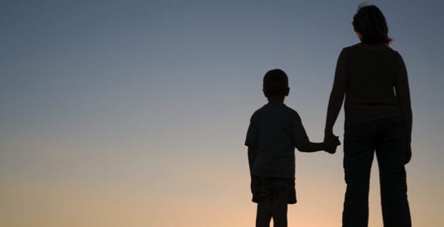 Silhouettes of mother and son at sunset