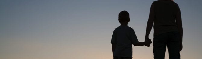 Silhouettes of mother and son at sunset