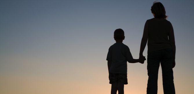 Silhouettes of mother and son at sunset