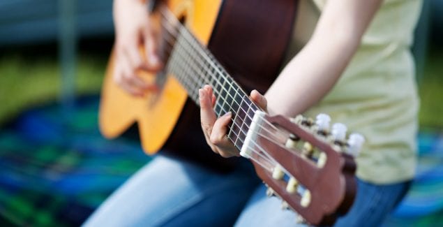 Young girl making music and playing guitar