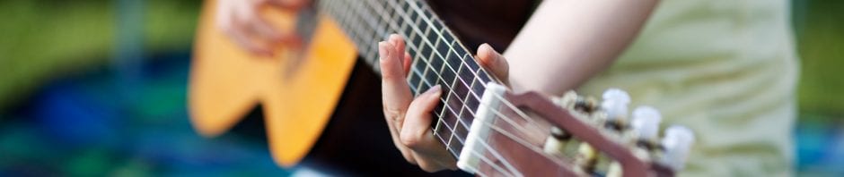 Young girl making music and playing guitar