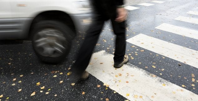 man crossing the street about to get hit by a car