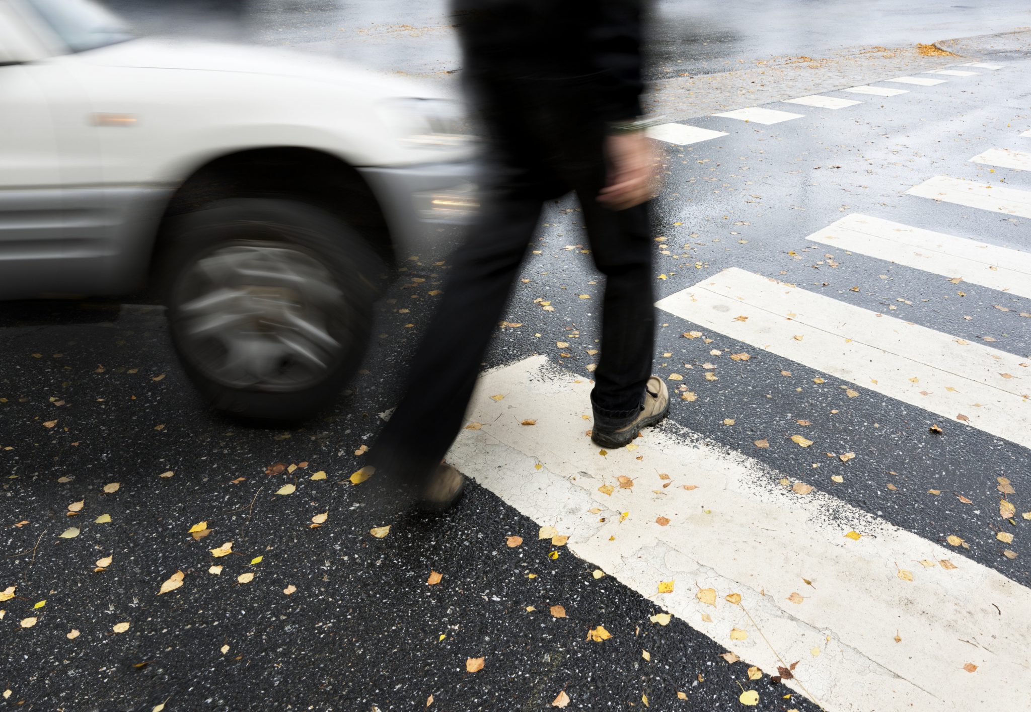 man crossing the street about to get hit by a car