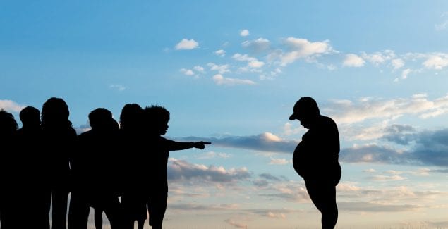 Childhood obesity - Children expel fat boy - silhouettes on background of sky