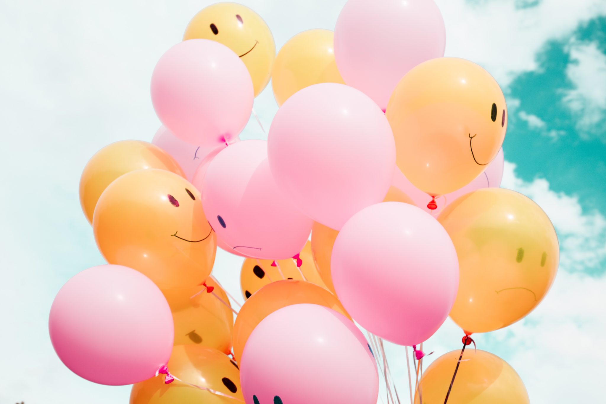 Mixed bunch of pink and orange smiley-face balloons