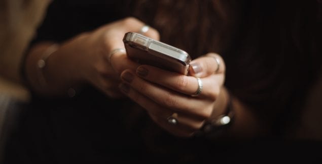 Closeup of young girls hands cupping a gripping a smartphone