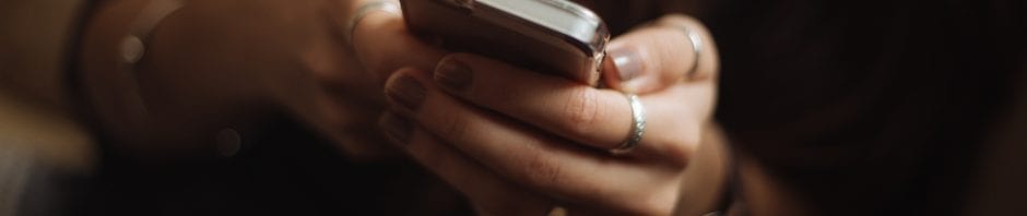 Closeup of young girls hands cupping a gripping a smartphone