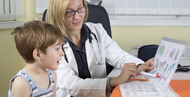 school evaluation - female child psychologist sits with grade school boy at a table