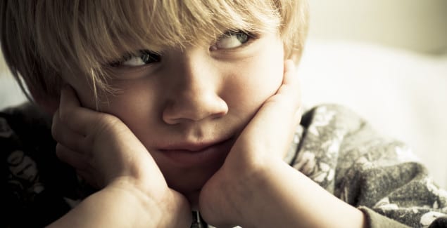 Specific Phobias - Young boy leaning his cheeks on his hands looking worried